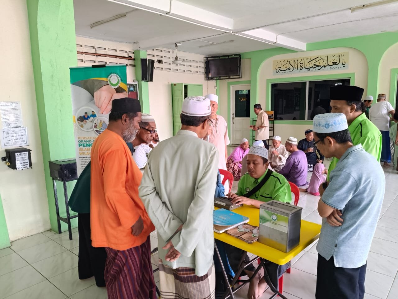 Ahli dan sukarelawan PERTIS berkumpul di meja kutipan derma semasa program kebajikan