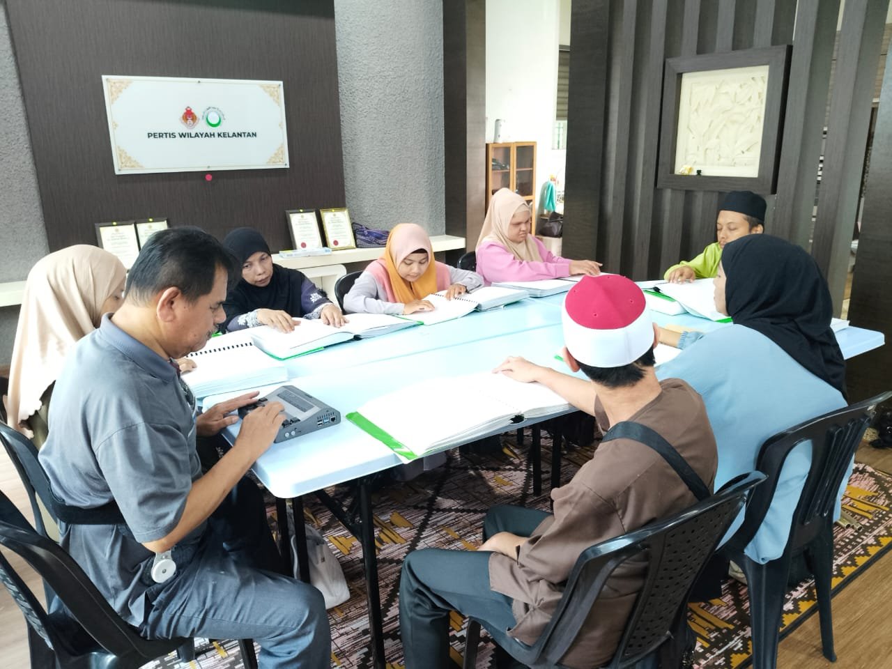Ahli PERTIS Wilayah Kelantan membaca Al-Quran Braille beramai-ramai di pejabat persatuan